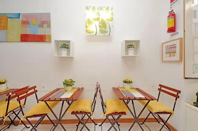 a table and chairs with yellow cushions in a room at Opera Inn Suites - Rooms and Apartments in Rome