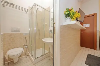 a bathroom with a shower and a toilet and a sink at Opera Inn Suites - Rooms and Apartments in Rome