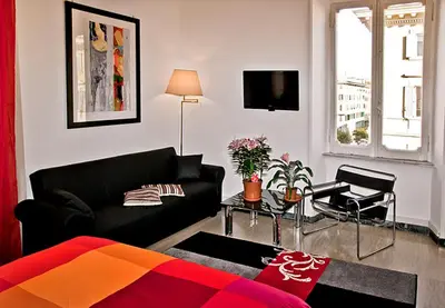 a living room with a black couch and a tv at Vatican Paradise in Rome