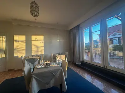 a dining room with two tables and a large window at All Comfort Astoria Palace in Rome