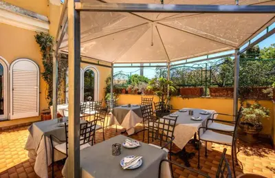 a restaurant with tables and chairs and a large umbrella at All Comfort Astoria Palace in Rome