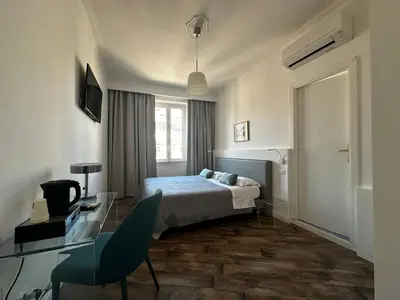 a hotel room with a bed and a desk and a window at All Comfort Astoria Palace in Rome