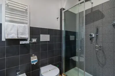a bathroom with a glass shower and a toilet at OTTO Rooms & Photogallery in Rome