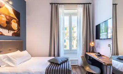 a bedroom with a bed and a desk and a window at OTTO Rooms & Photogallery in Rome