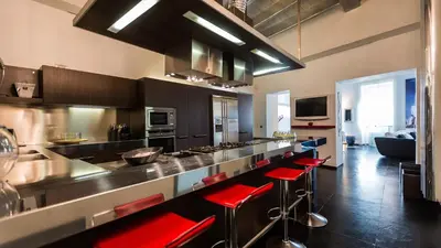 a kitchen with a counter with red bar stools at Rental in Rome Cosmopolitan hi-tech in Rome