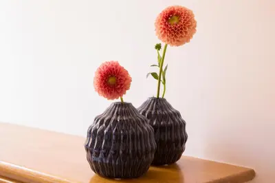 two vases with flowers in them sitting on a table at ROMAC Condotti with 3 bedrooms near the Spanish Steps in Rome