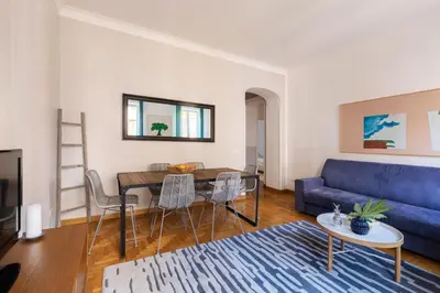 a living room with a blue couch and a table at ROMAC Condotti with 3 bedrooms near the Spanish Steps in Rome