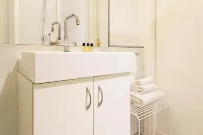 a white bathroom with a sink and a mirror at ROMAC Condotti with 3 bedrooms near the Spanish Steps in Rome