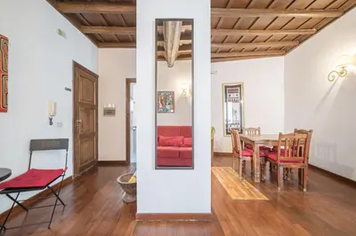 a dining room with a table and a red couch at Panetteria Apartment in Rome