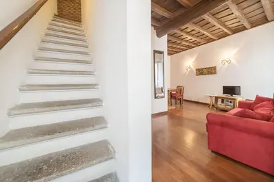a staircase in a living room with a red couch at Panetteria Apartment in Rome