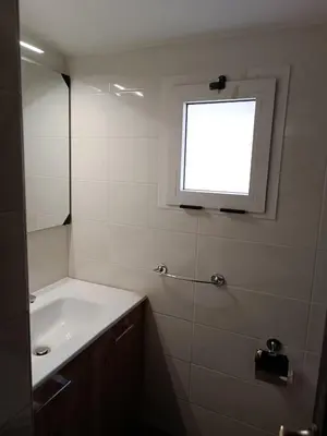 a white bathroom with a sink and a window at Panetteria Apartment in Rome