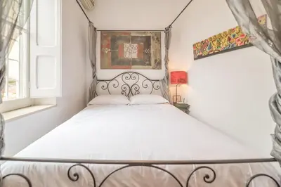 a bedroom with a white bed with a metal frame at Panetteria Apartment in Rome