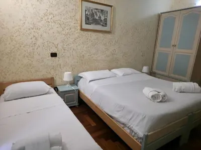 two twin beds in a bedroom with a picture on the wall at St. Peter's Rooms Rome in Rome