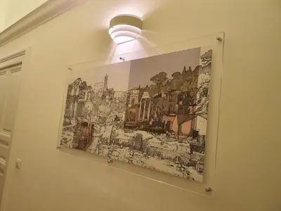 a painting hanging on a wall with a light at Luxury & Charme Colosseo in Rome