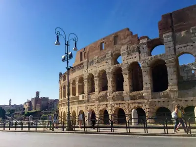 a large building with people walking in front of it at Luxury & Charme Colosseo in Rome