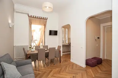 a living room with a table and a dining room at Luxury & Charme Colosseo in Rome