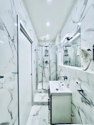 a white bathroom with a shower and a sink at Lifestyle Veneto Suite in Rome