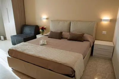 a bedroom with a large bed and a chair at Lifestyle Veneto Suite in Rome