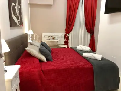 a bedroom with a red bed with pillows on it at Lifestyle Veneto Suite in Rome