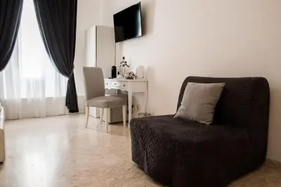 a living room with a chair and a desk at Lifestyle Veneto Suite in Rome