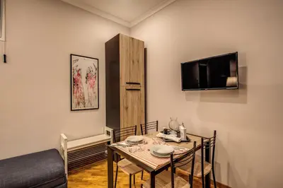 a dining room with a table and a tv at Appartamento via del Pantheon in Rome