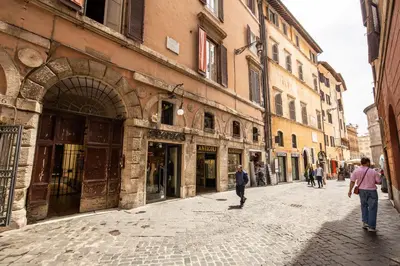 a group of people walking down a street with buildings at Appartamento via del Pantheon in Rome