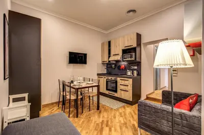 a living room with a table and a kitchen at Appartamento via del Pantheon in Rome