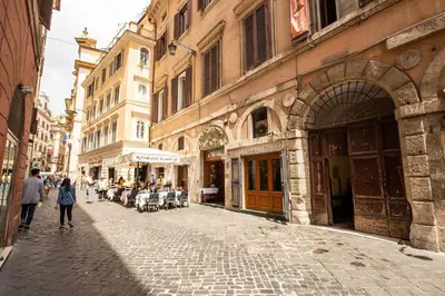 a group of people walking down a street with buildings at Appartamento via del Pantheon in Rome