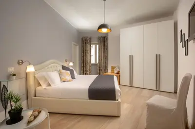 a bedroom with a white bed and a chair at Vatican 84 in Rome