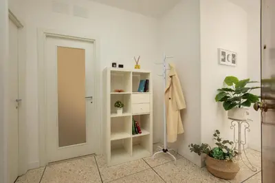 a room with a white book shelf next to a door at Vatican 84 in Rome