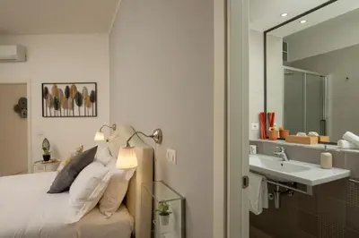 a bedroom with a bed with a sink and a mirror at Vatican 84 in Rome