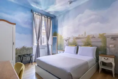 a bedroom with a bed with a painting on the wall at Suites Trastevere in Rome