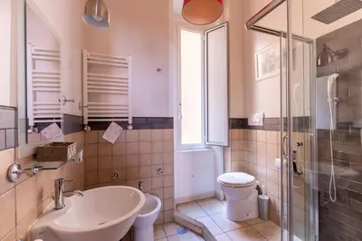 a bathroom with a sink and a toilet and a shower at Suites Trastevere in Rome