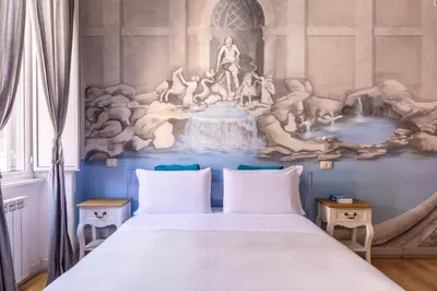 a bedroom with a large bed with a painting on the wall at Suites Trastevere in Rome