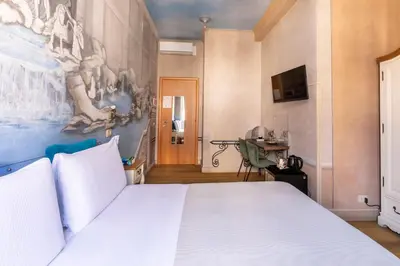 a bedroom with a white bed and a painting on the wall at Suites Trastevere in Rome
