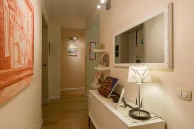 a hallway with a mirror and a table with a lamp at Suites Trastevere in Rome