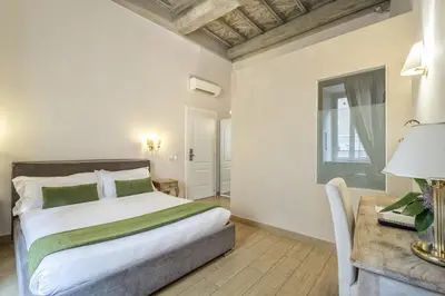 a bedroom with a bed and a table and a window at Little Queen Suite in Rome