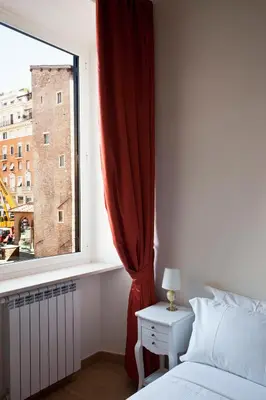a bedroom with a window with a red curtain at Little Queen Suite in Rome