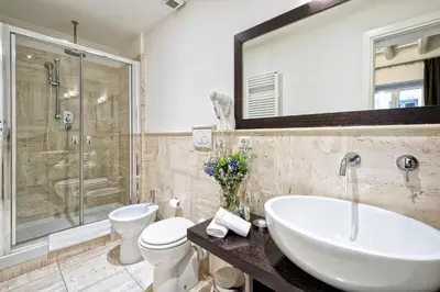 a bathroom with a sink and a toilet and a shower at Little Queen Suite in Rome