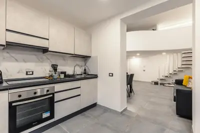 a kitchen with white cabinets and a stove at Nvmen Apartment con Terrazza al Colosseo in Rome