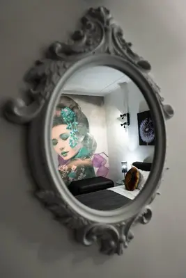 a mirror on a wall with a picture of a woman at Trevi & Pantheon Design Rooms in Rome