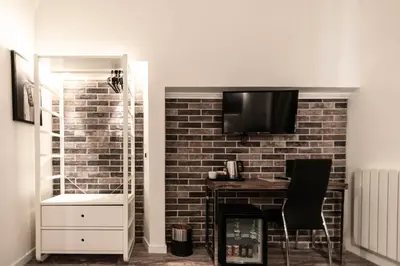 a living room with a tv on a brick wall at Trevi & Pantheon Design Rooms in Rome