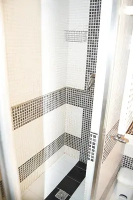 a bathroom with a shower with black and white tiles at Domus Mazzini in Rome