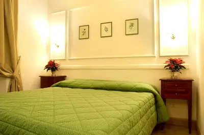 a bedroom with a bed with a green comforter at Domus Mazzini in Rome
