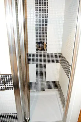 a shower with black and white tiles in a bathroom at Domus Mazzini in Rome