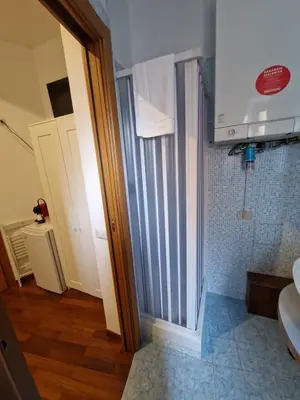 a bathroom with a sliding shower door and a toilet at Pepe's Place - Re di Roma in Rome