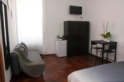 a bedroom with a bed and a tv and a chair at Pepe's Place - Re di Roma in Rome
