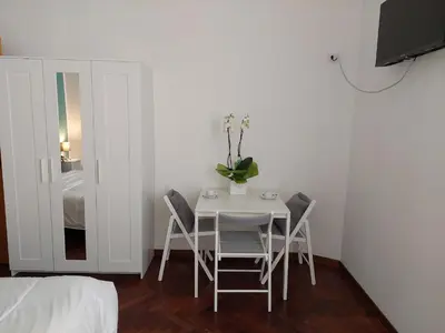 a white dining room table with chairs and a vase with flowers at Pepe's Place - Re di Roma in Rome