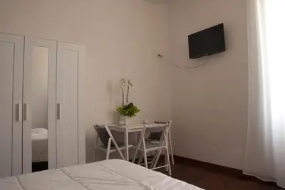 a bedroom with a table and a tv on the wall at Pepe's Place - Re di Roma in Rome