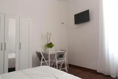 a bedroom with a table and a tv on the wall at Pepe's Place - Re di Roma in Rome